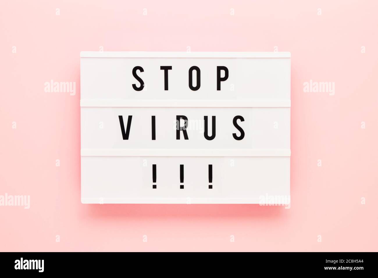 STOP VIRUS è scritto in lightbox su sfondo rosa. Concetto sanitario e medico. Vista dall'alto, spazio di copia. Concetto di quarantena. Foto Stock