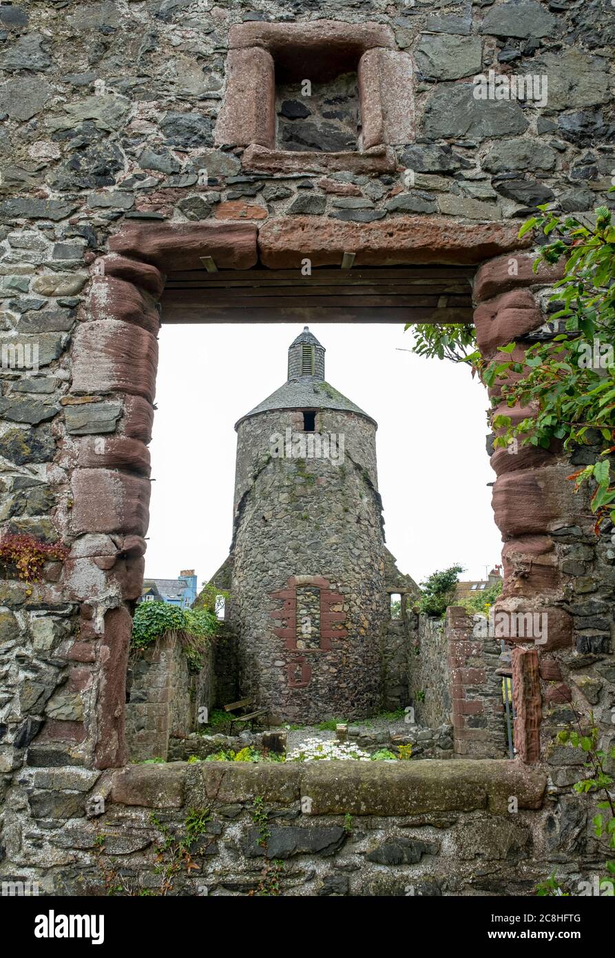 Una vista che guarda attraverso una finestra della chiesa di una torre celtica nel cimitero di St Andrew's Kirk a Portpatrick. Foto Stock