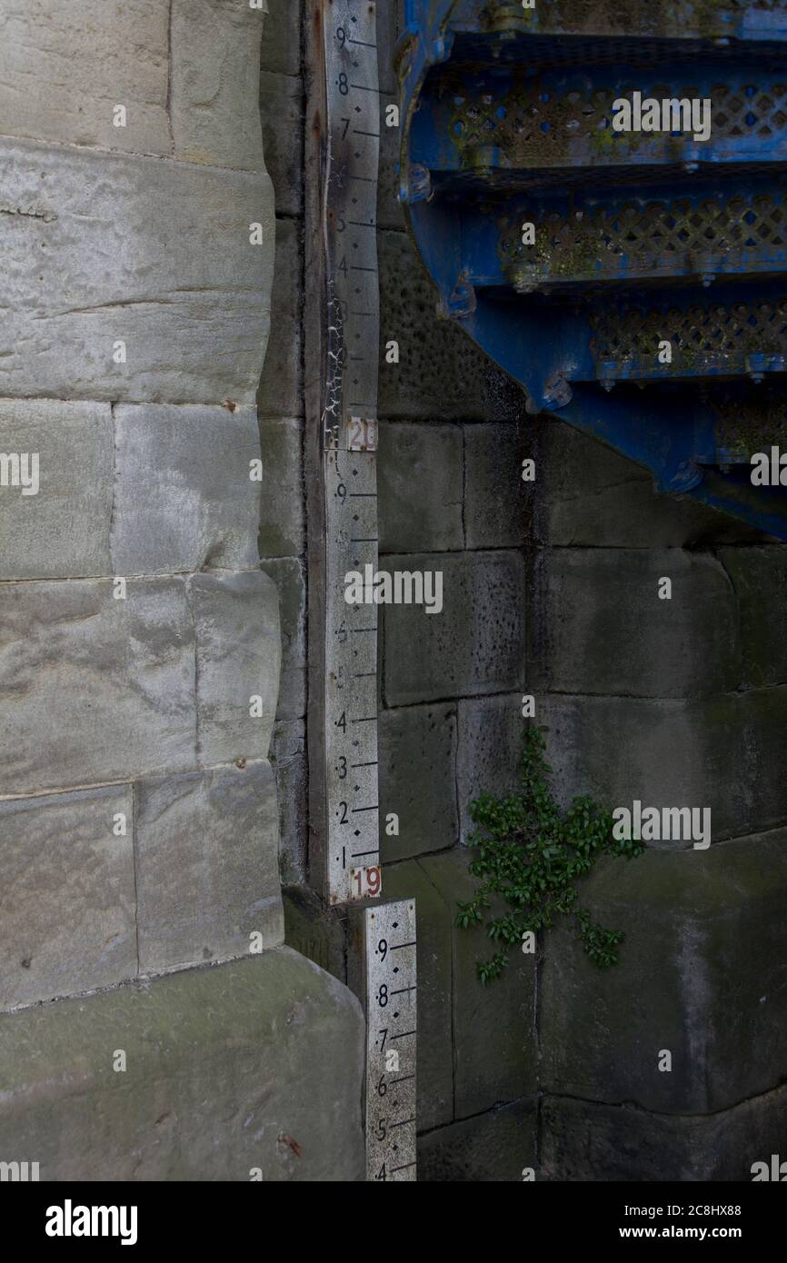 Colonna delle alluvioni lungo un fiume, sotto un ponte, in un villaggio, inondazioni, meteo, indicatore delle alluvioni, righello delle alluvioni, conservazione dei record, allerta delle alluvioni, preparazione Foto Stock