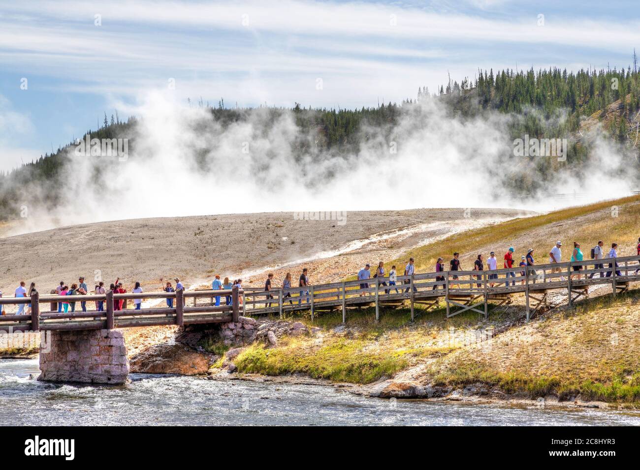 Wyoming, USA - 24 agosto 2019: I visitatori si avvicinano al ponte pedonale per la Grande Primavera prismatica nel Parco Nazionale di Yellowstone con il vapore che si erge dalla terma Foto Stock