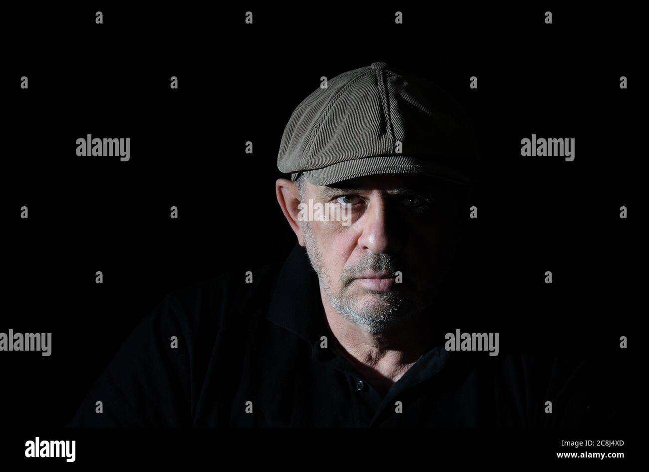 Ritratto dell'anziano in abiti neri su sfondo nero Foto Stock