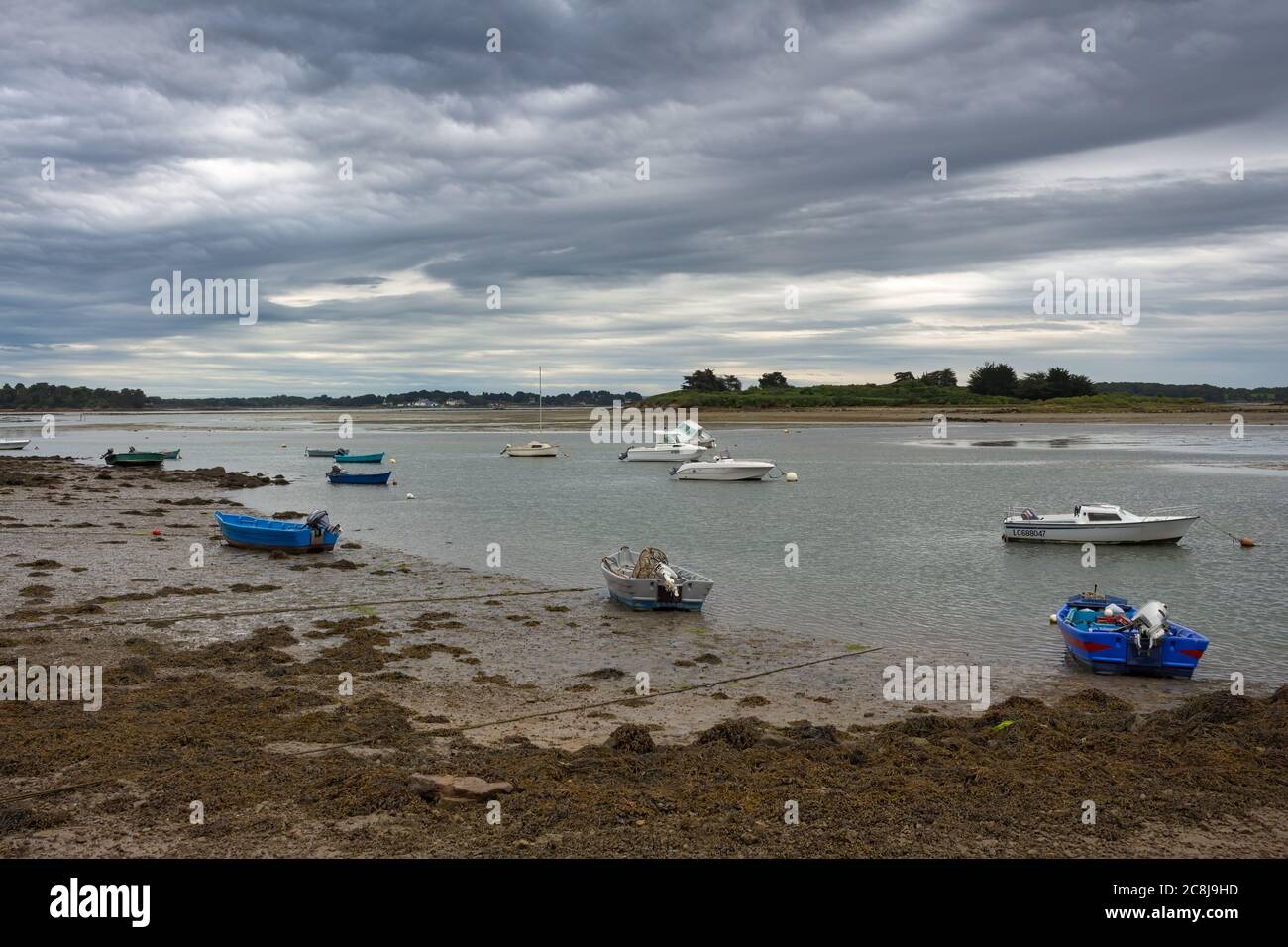 ÎLE DU SAINT-CADO, BRETAGNA, FRANCIA: Vista del porto di pesca dove le chiatte rimangono ancorate a bassa marea Foto Stock