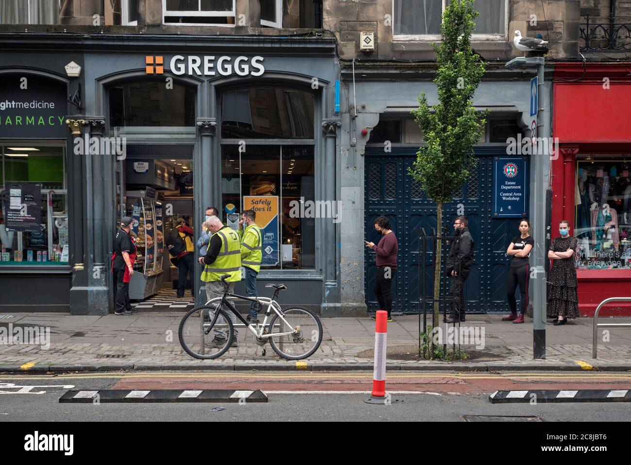 Una coda socialmente distanziata fuori da una filiale di Greggs the Bakers al tempo di Covid-19 a Forrest Road, Edimburgo, Scozia, Regno Unito. Foto Stock
