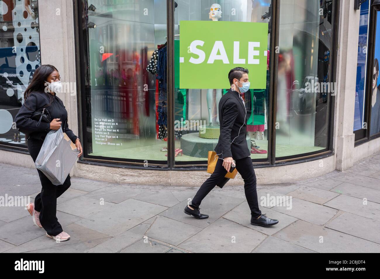 Il giorno in cui le linee guida per gli acquirenti in Inghilterra sono in covidio, il giorno in cui l'uso di rivestimenti facciali nei negozi diventa obbligatorio, gli acquirenti che indossano maschere passeranno Harvey Nichols a Knightsbridge, il 24 luglio 2020, a Londra, Inghilterra. Foto Stock