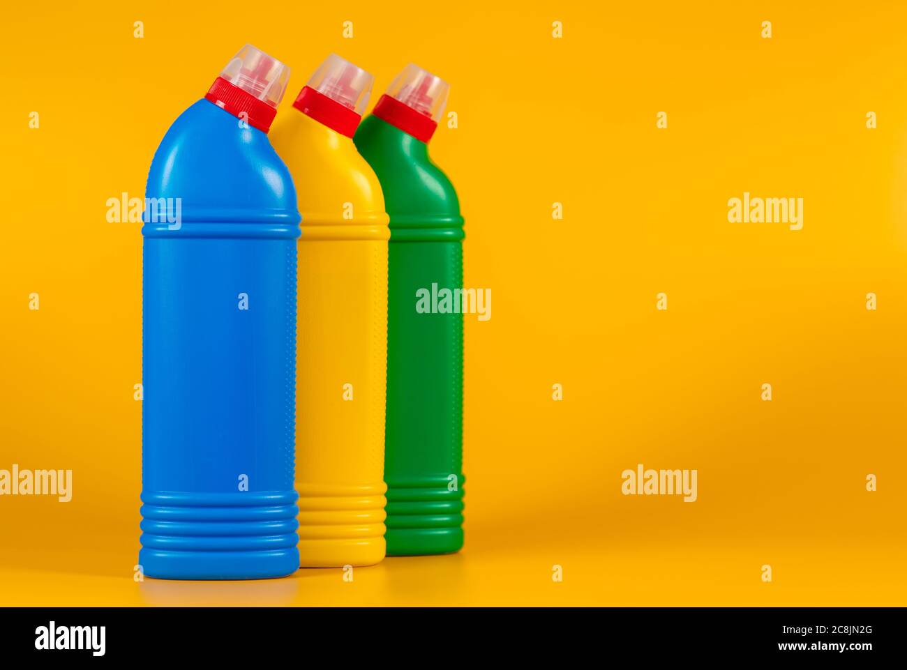 flaconi multicolore con detergente su sfondo giallo. Foto Stock