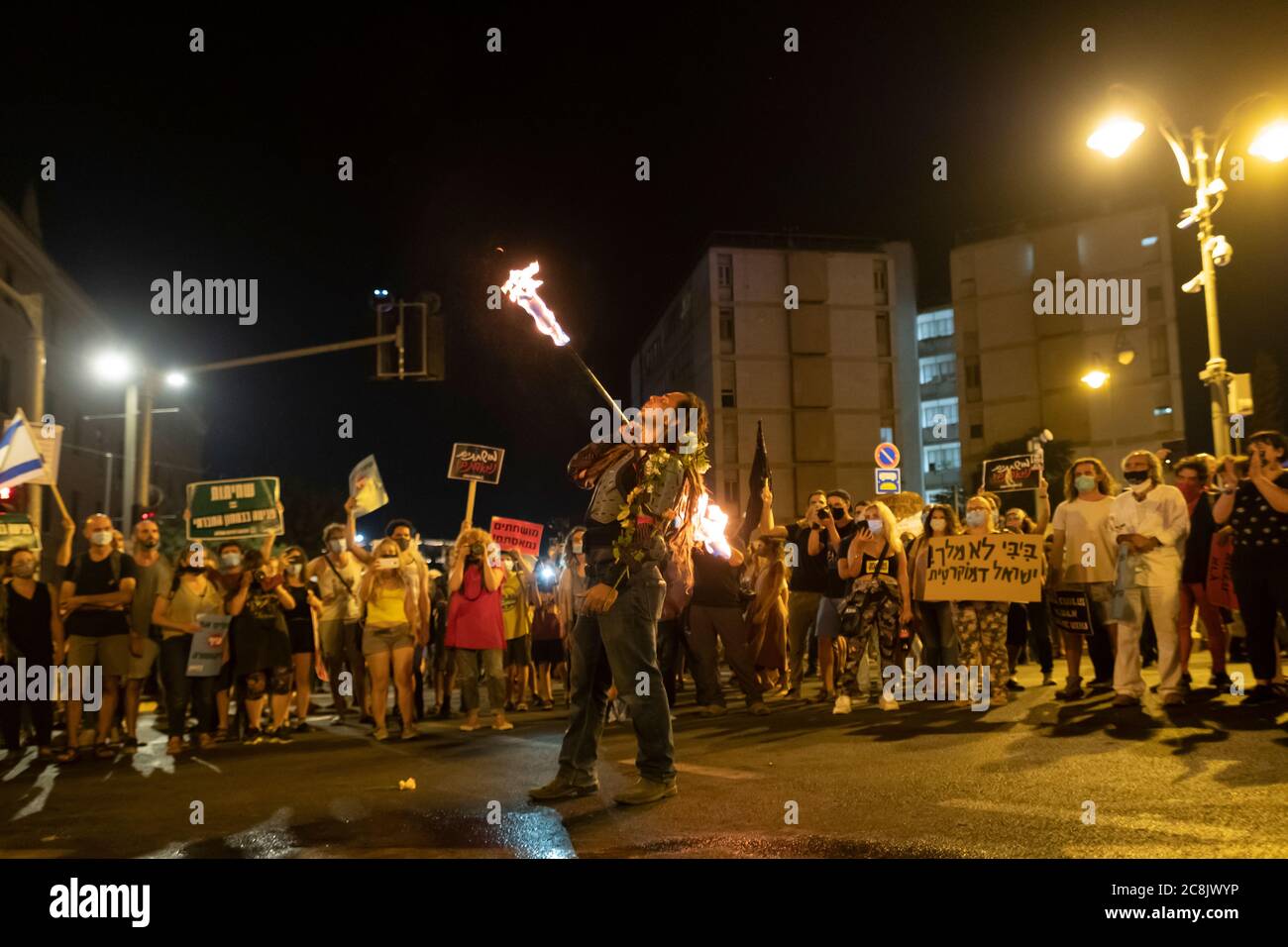 Il manifestante sputa il fuoco mentre migliaia di manifestanti massacravano fuori dalla residenza ufficiale del primo ministro Benjamin Netanyahu a Gerusalemme, chiedendo le sue dimissioni per le sue accuse di corruzione e ciò che chiamano cattiva gestione della crisi del coronavirus e danneggiando la democrazia a Gerusalemme, Israele. Foto Stock