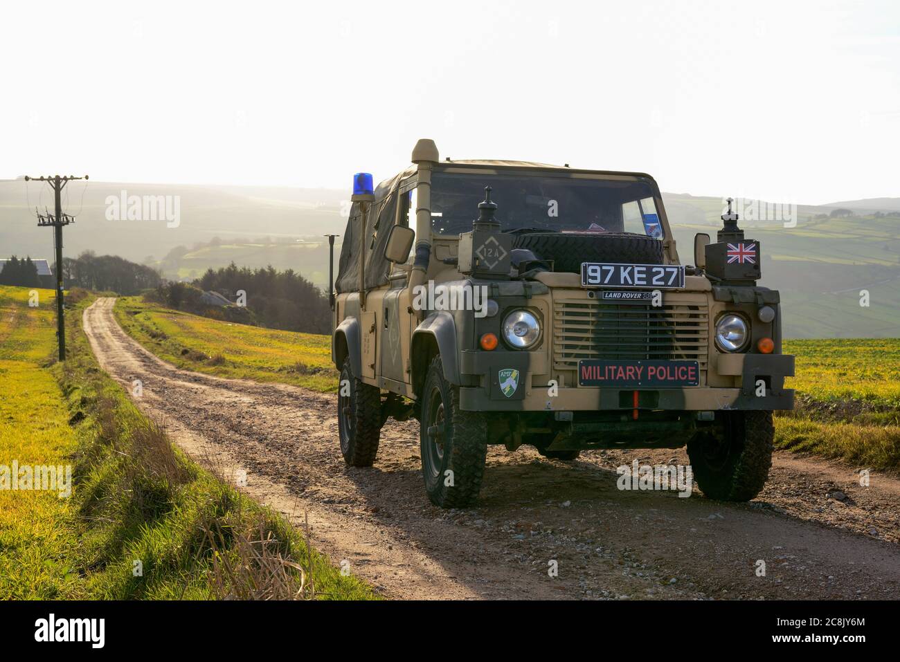 Carrello radio a passo lungo della polizia militare Land Rover parcheggiato su una pista di un'azienda agricola Foto Stock