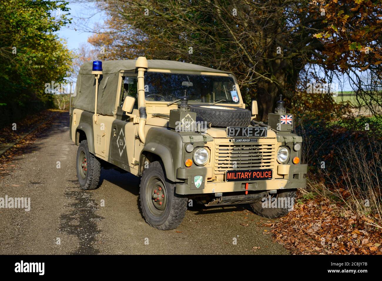 Carrello radio a passo lungo della polizia militare Land Rover parcheggiato su una corsia di campagna. Foto Stock