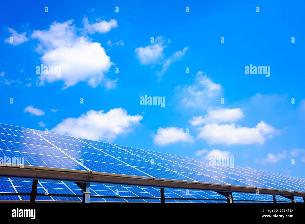 Installazione di pannelli solari in una zona montana con nuvole blu. Foto Stock