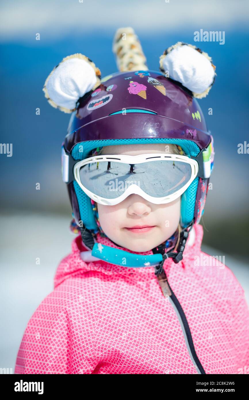 Ritratto di carina ragazza sciatrice felice in casco e occhiali di  protezione in una stazione sciistica invernale Foto stock - Alamy