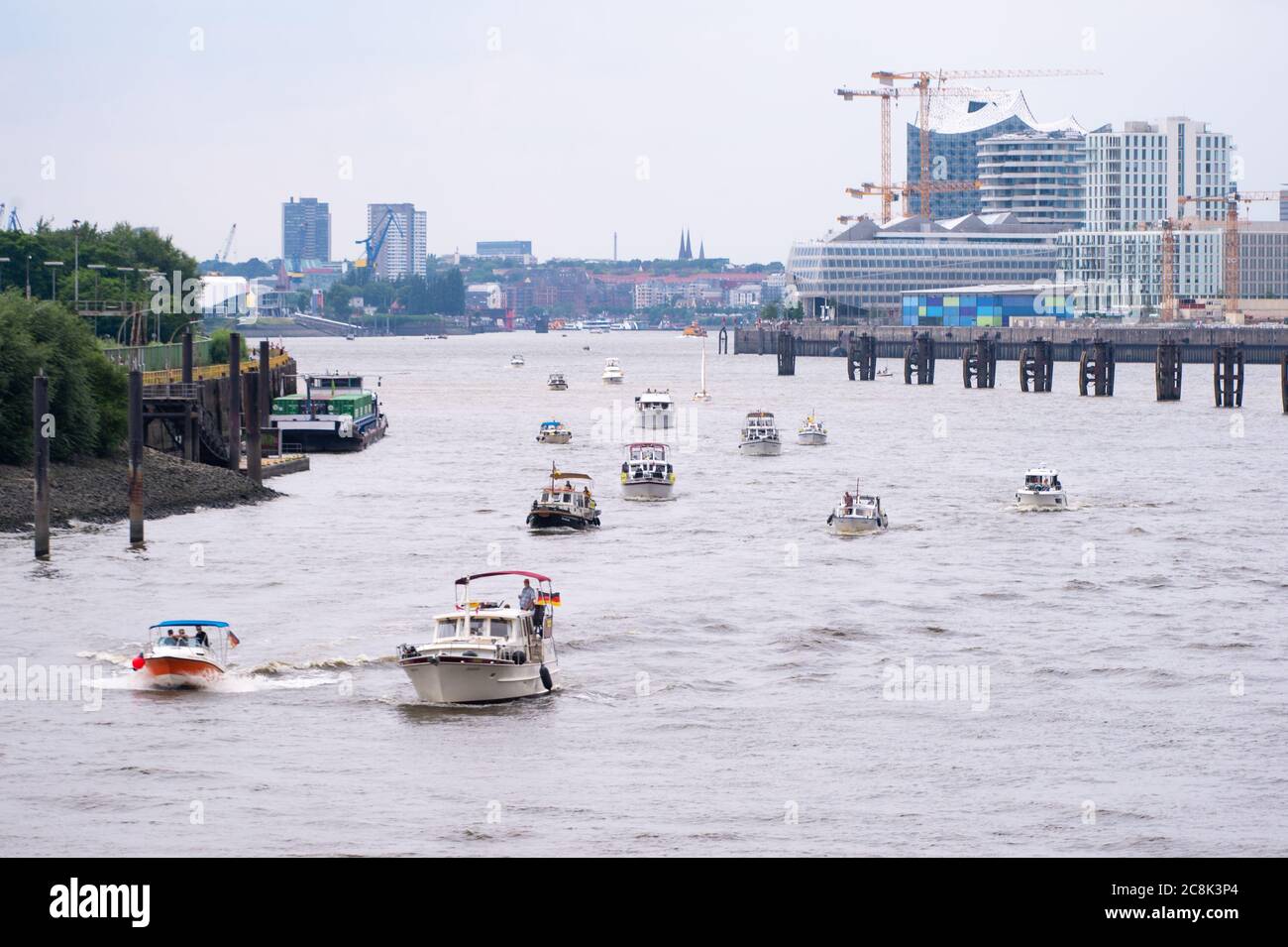 25 luglio 2020, Amburgo: Diverse barche a motore guidano come colonna sulla Norderelbe, sullo sfondo si possono vedere la Landungsbrücken e la Hafenity con Unilever House e la sala concerti Elbphilharmonie. Secondo la polizia, 100 barche erano scese in direzione della Landungsbrücken durante una dimostrazione dell'iniziativa dei cittadini 'Move-Elba-reten'. Secondo gli iniziatori, la dimostrazione era diretta contro le considerazioni di aprire la dove Elba alla serratura di Tatenberg verso l'Elba settentrionale e quindi renderla un'acqua di marea. Ciò minaccerebbe le associazioni locali e la compan Foto Stock