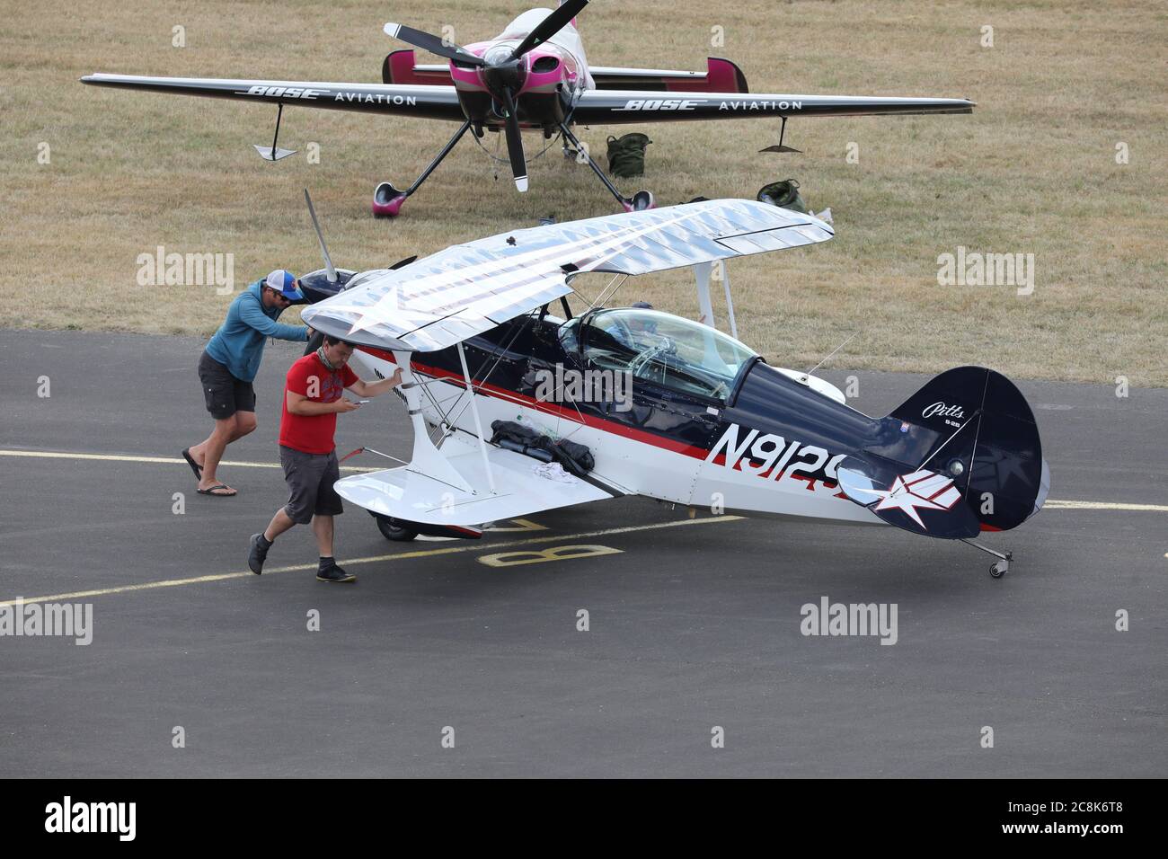 Gera, Germania. 25 luglio 2020. I membri dell'equipaggio spingono un aereo biplanare Pitts S2S sul grembiule dell'aerostazione Gera-Leumnitz per ricaricarsi, ai campionati tedeschi di aerobica motorizzata. In sei giorni 32 partecipanti hanno lottato qui per il titolo. Credit: Bodo Schackow/dpa-zentralbild/dpa/Alamy Live News Foto Stock