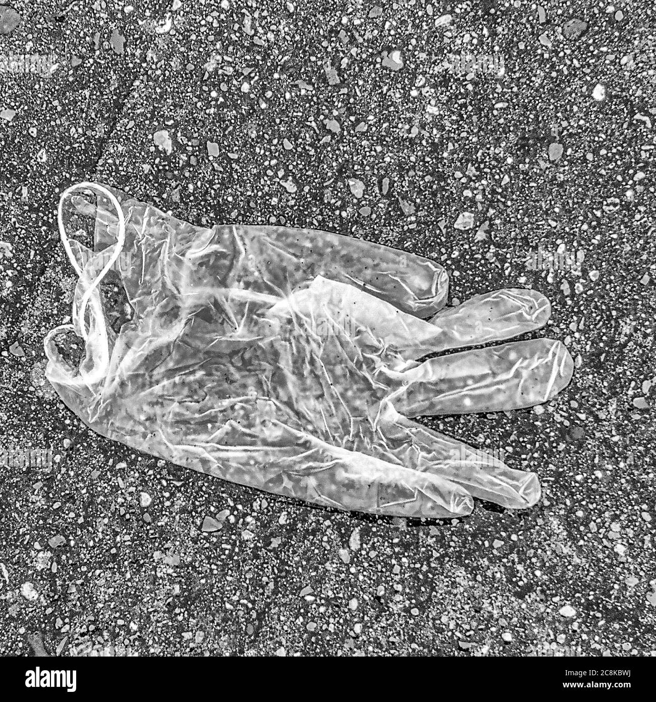 Guanto chirurgico utilizzato per la protezione da covid-19 scartato su una via pubblica a Rayleigh, Essex. Foto Stock