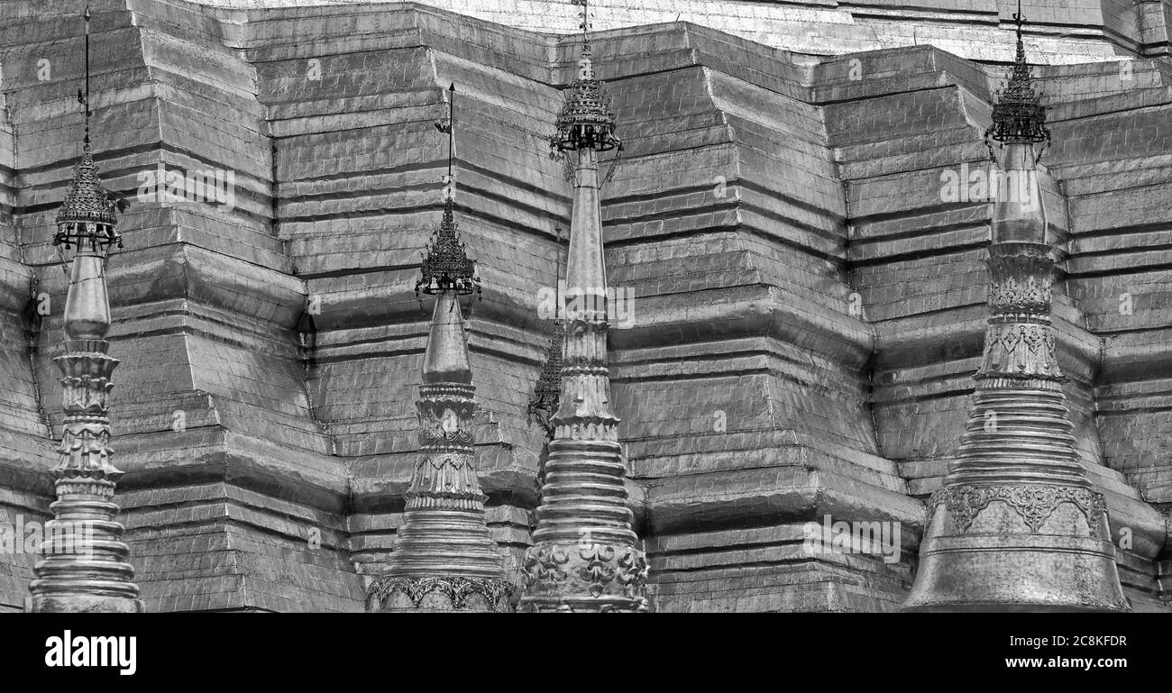 I magnifici stupa placcati oro che circondano la Pagoda Shwedagon a Yangon, Myanmar, formalmente Rangoom, Birmania in bianco e nero monocromatico Foto Stock