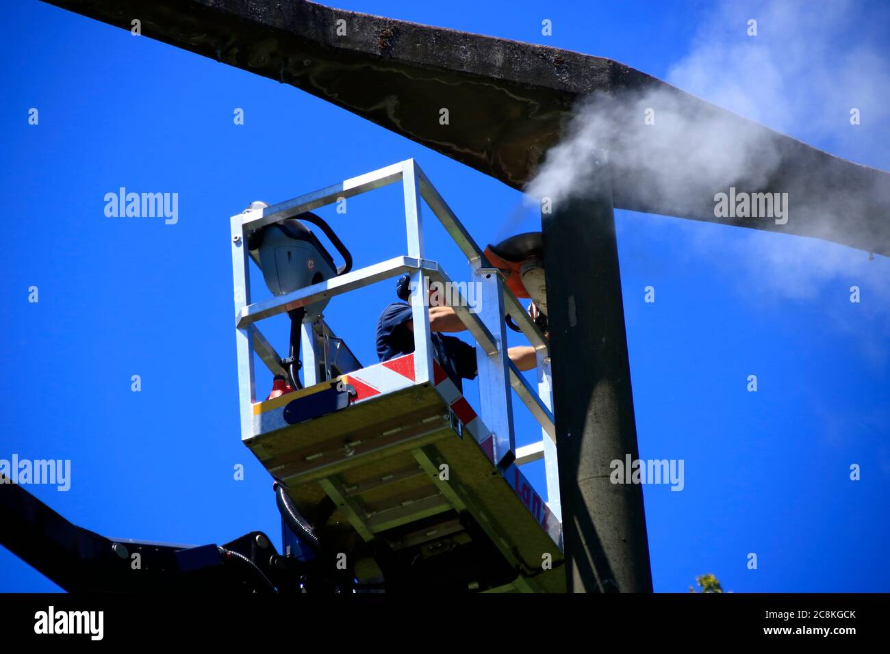 Lavorare su un pilone ad alta tensione con una piattaforma di lavoro Foto Stock