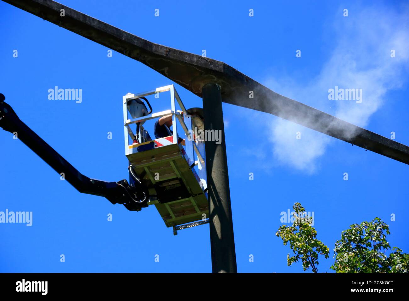 Lavorare su un pilone ad alta tensione con una piattaforma di lavoro Foto Stock