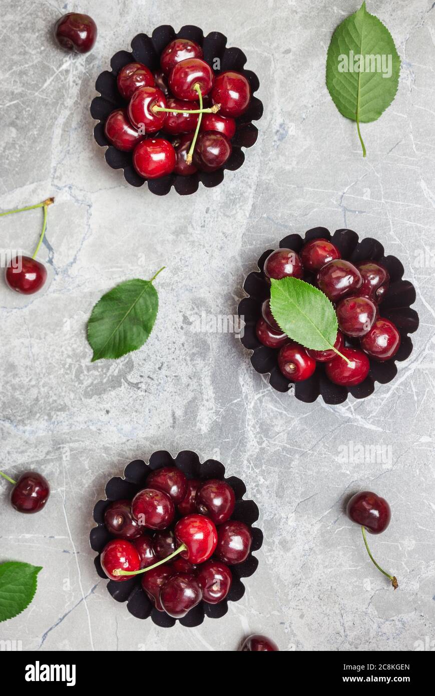 Composizione piatta con ciliegie dolci su tavola di marmo, spazio per testo. Foto Stock