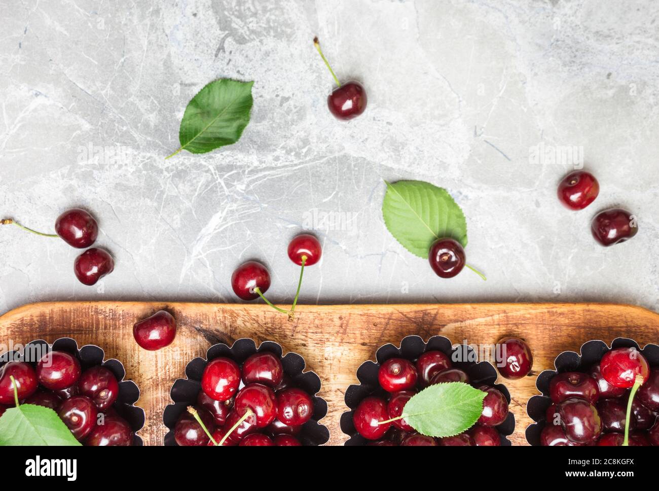 Composizione piatta con ciliegie dolci su tavola di marmo, spazio per testo. Foto Stock