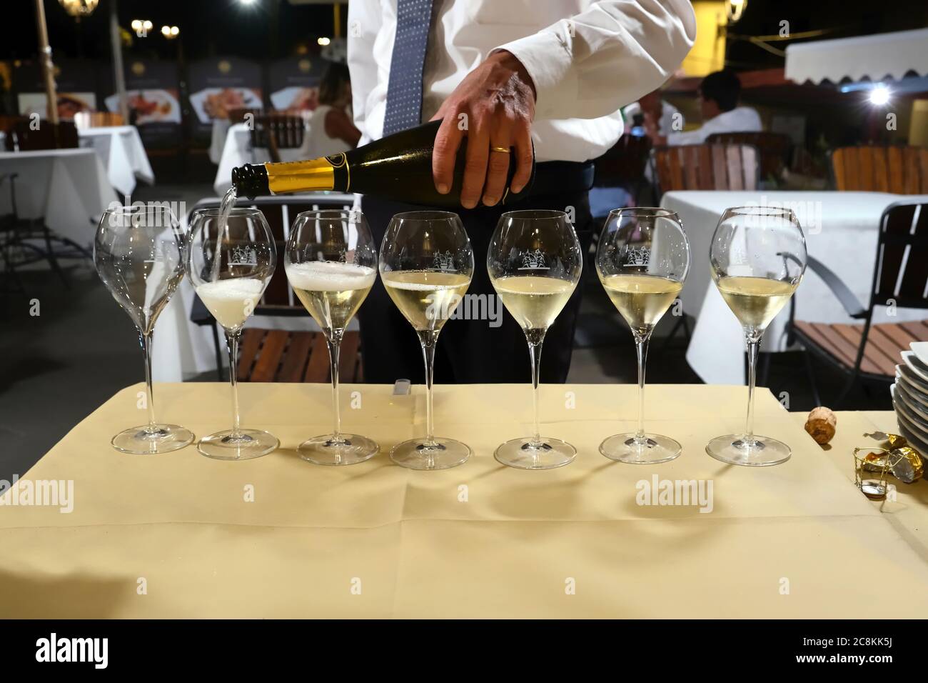 Un sommelier versa un prosecco nei bicchieri di un ristorante Foto Stock