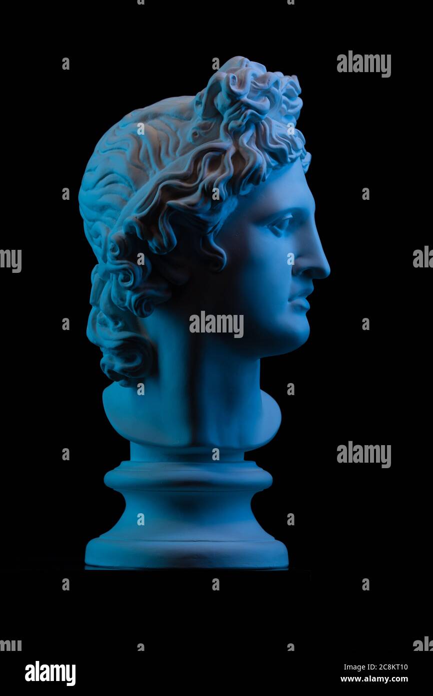 Statua in gesso di un busto di Apollo Belvedere in blu luce locale su sfondo nero Foto Stock