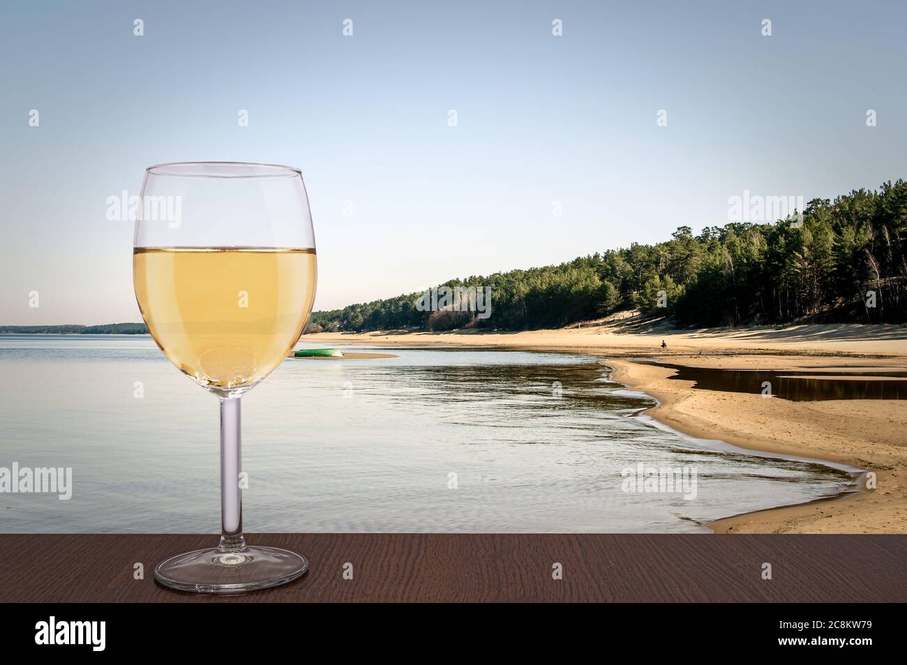 Bicchiere di vino bianco con vista sulla Duna Bianca e la vista sul Mar Baltico in primavera, Lettonia. Spiaggia con sabbia bianca e mare blu/oceano. Spiaggia con pineta Foto Stock