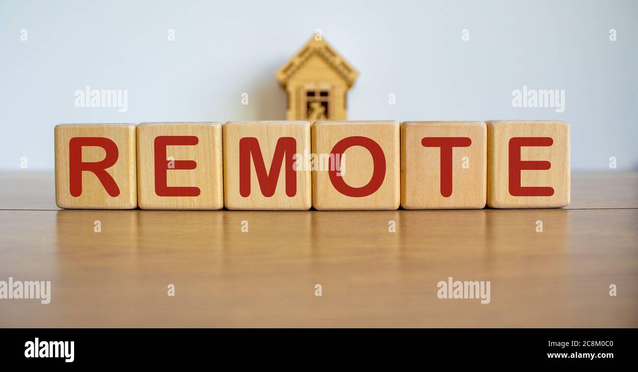 Concetto parola remoto su cubi su un bel tavolo di legno, modello di casa. Foto Stock