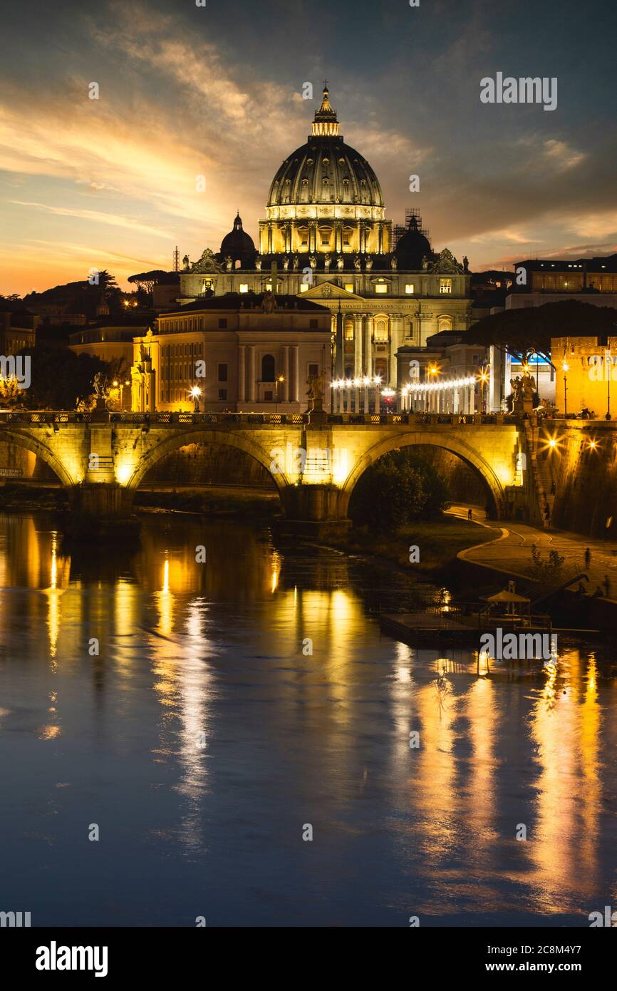 Le luci intorno al Vaticano e alla Basilica di San Pietro si riflettono nel Tevere di Roma. Foto Stock