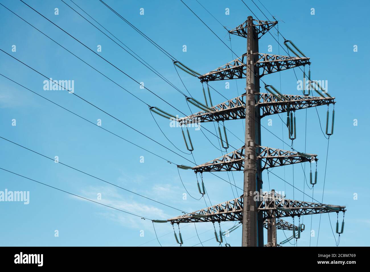Linea di trasmissione elettrica contro cielo blu chiaro. Torre ad alta tensione Foto Stock