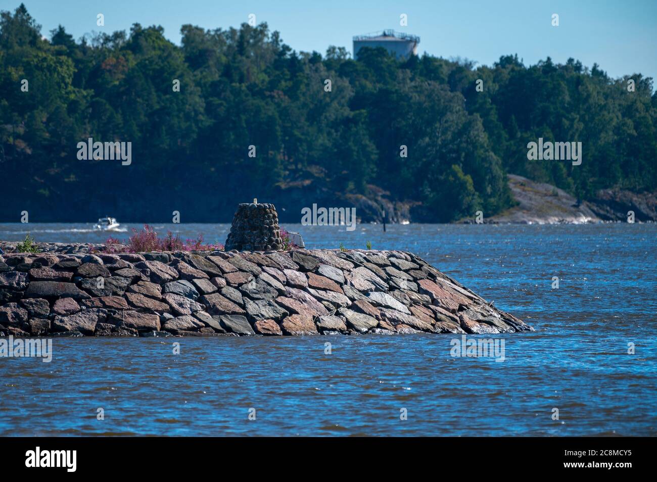 Una frangiflutti fatta di blocchi di granito sta riparando le barche di svago nel porto. Foto Stock