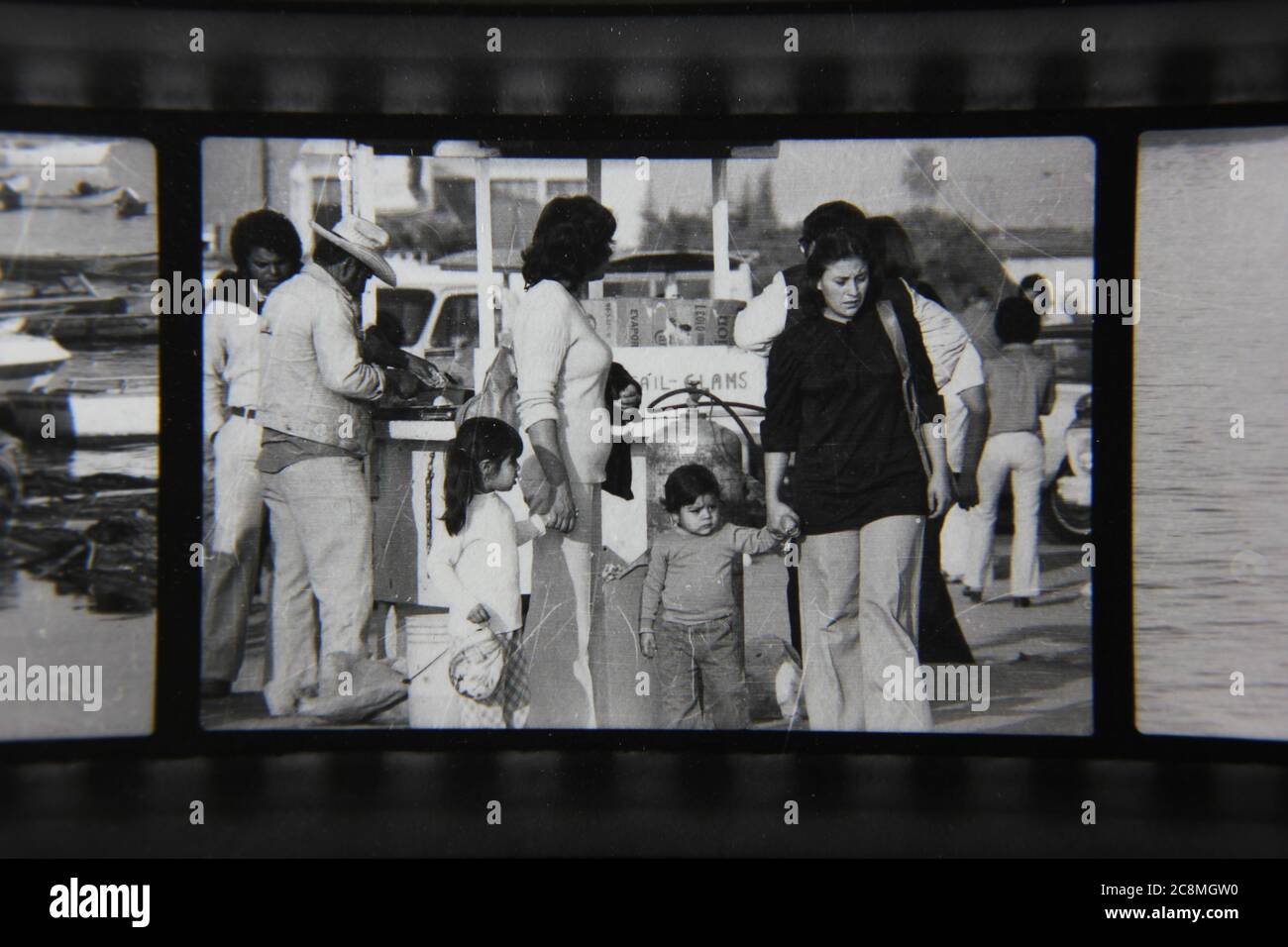 Bella fotografia in bianco e nero degli anni '70 di una famiglia che cammina intorno al porto. Foto Stock