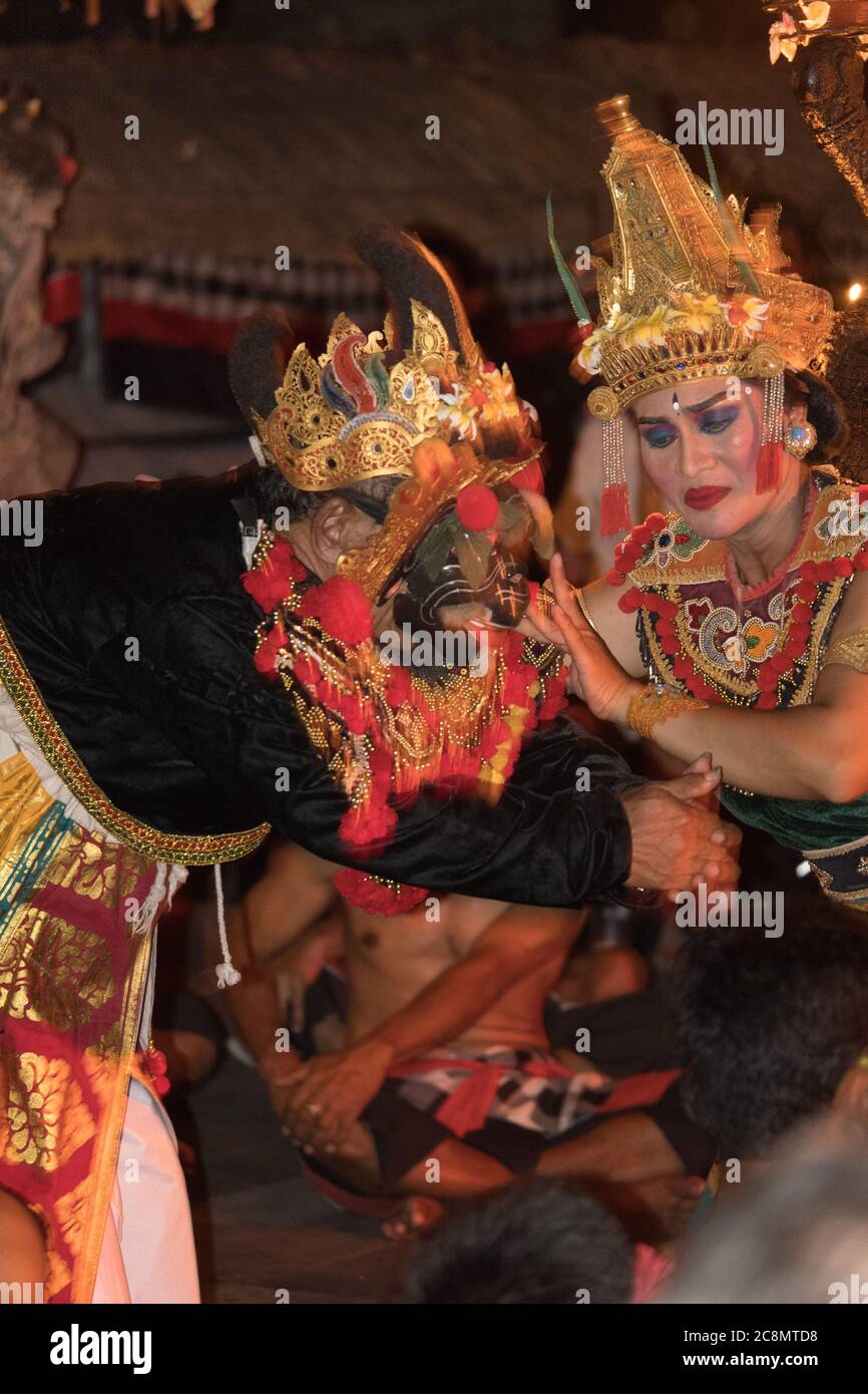 Foto drammatica di ballerini Kecak vestiti con colori colorati e vestiti in costumi tradizionali dai colori vivaci che eseguono la danza balinese del Tempio Ramayana Indù. Foto Stock