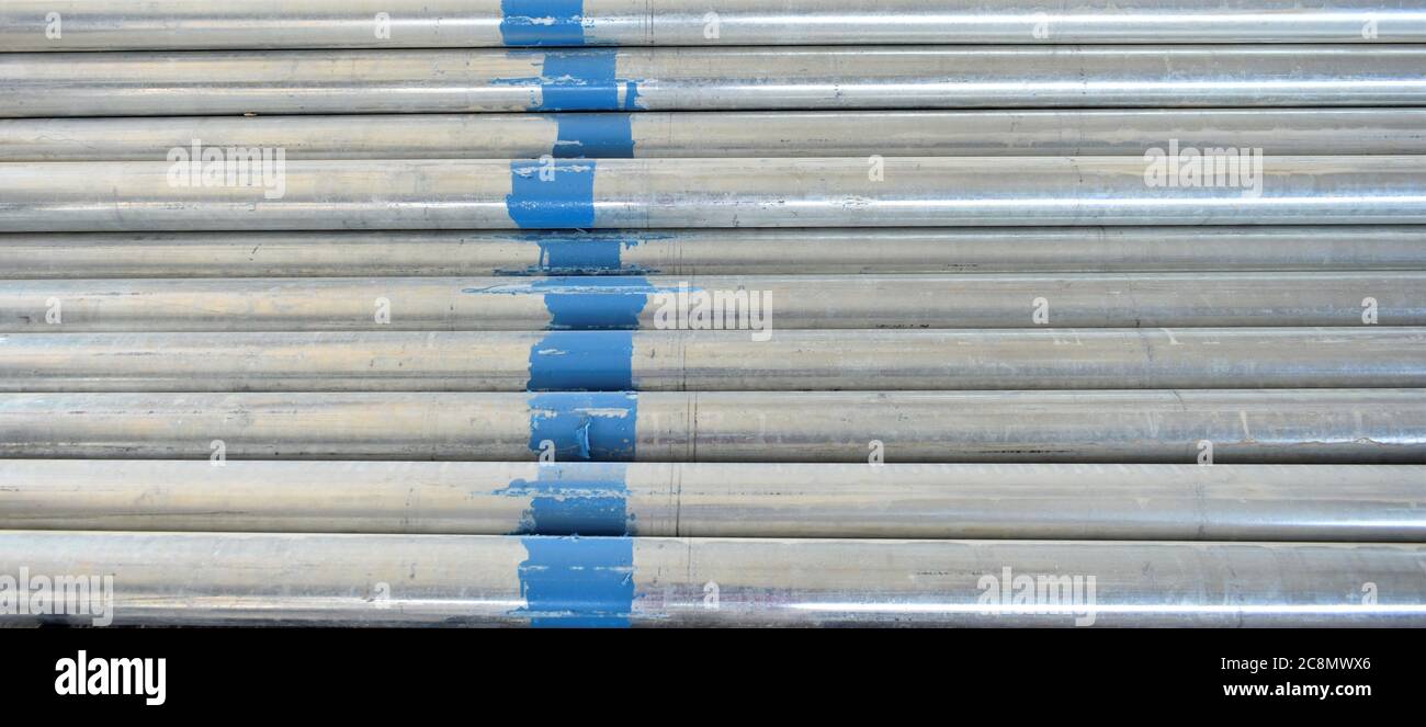 Tubi in acciaio GI in officina e tubi in acciaio galvanizzato sullo sfondo Foto Stock