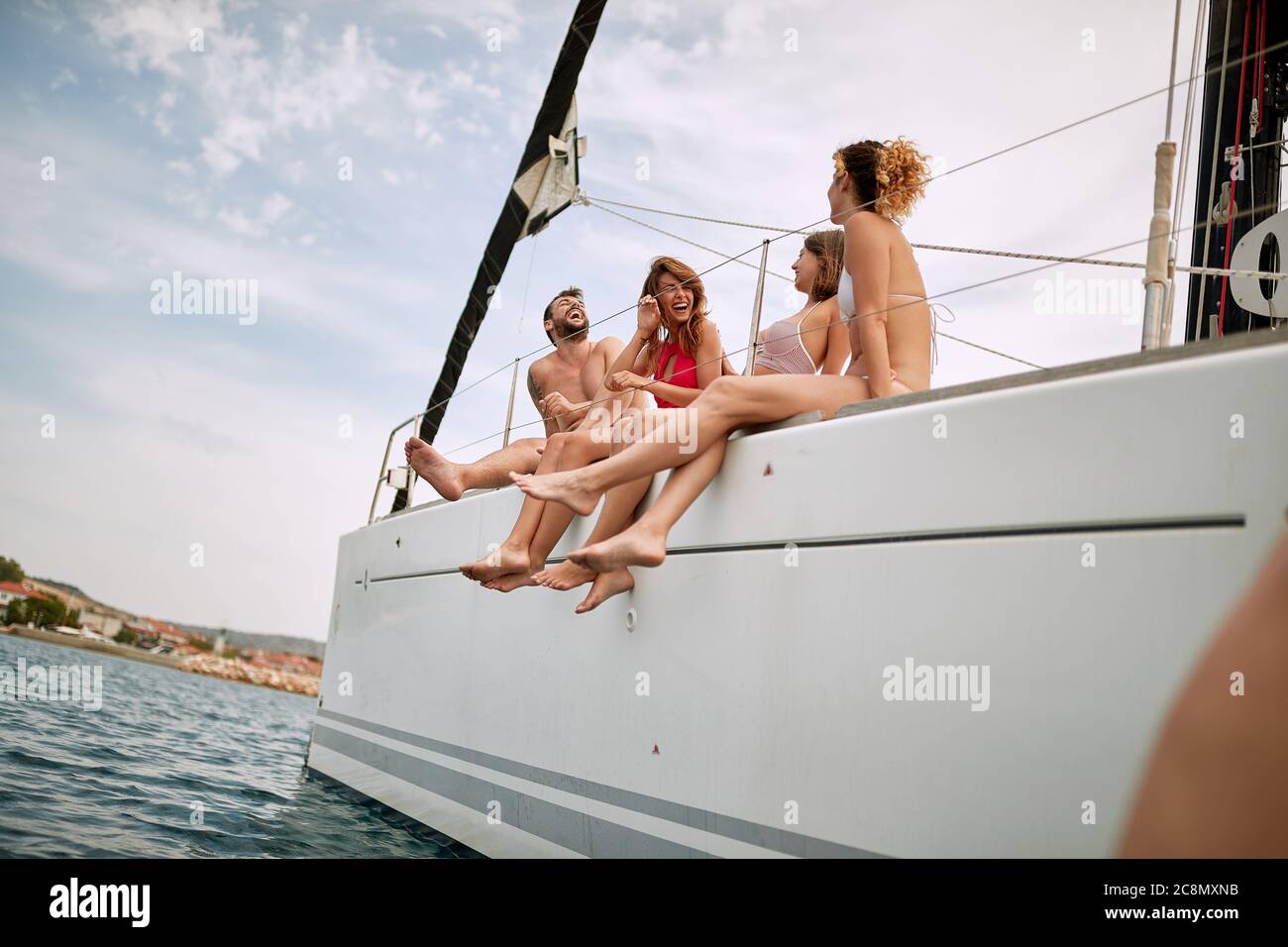 Amici seduti sul ponte di uno yacht in una giornata di sole Foto Stock