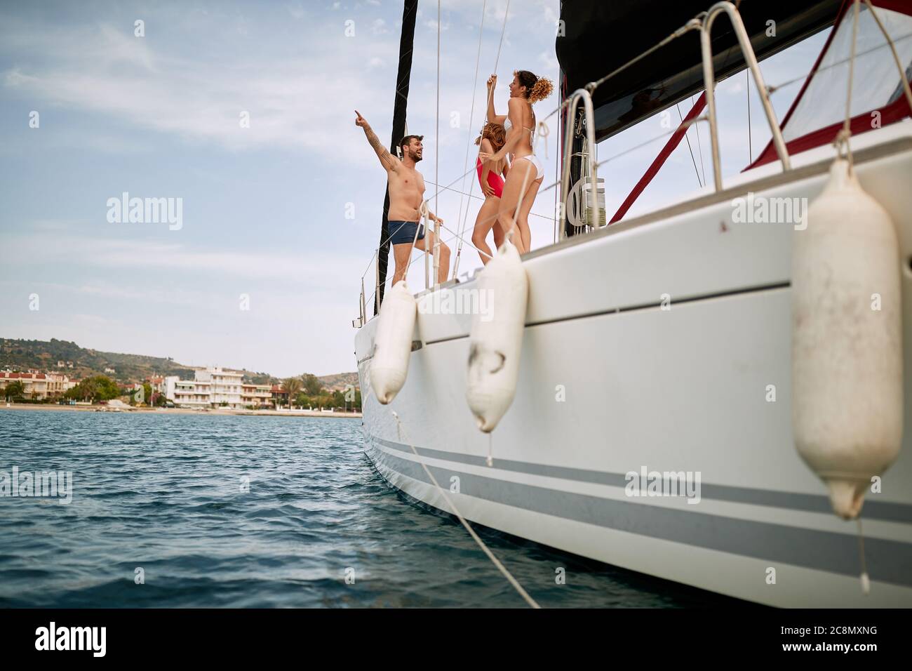 Amici che hanno un tempo meraviglioso sul ponte di uno yacht in una giornata di sole Foto Stock