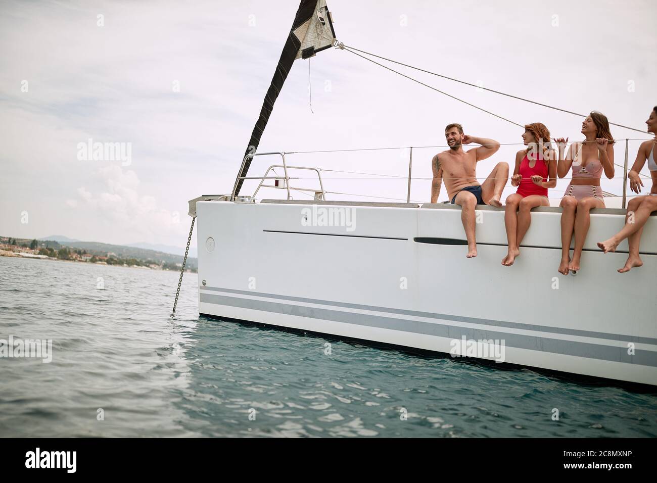 Amici che si rilassano sul ponte di uno yacht in una giornata di sole Foto Stock