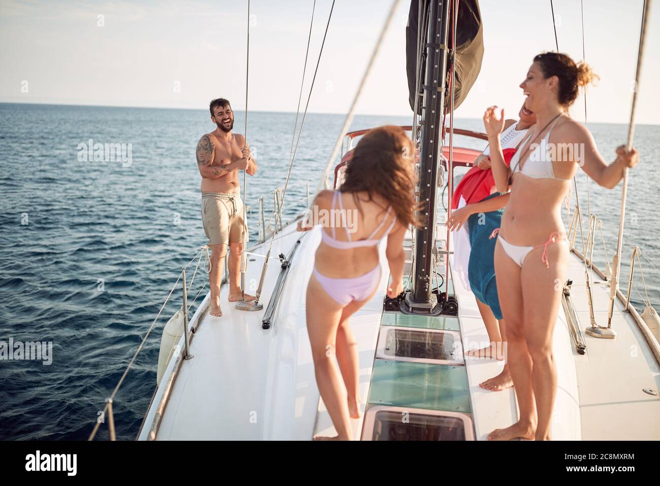 Amici che hanno tempo su uno yacht in una giornata di sole Foto Stock