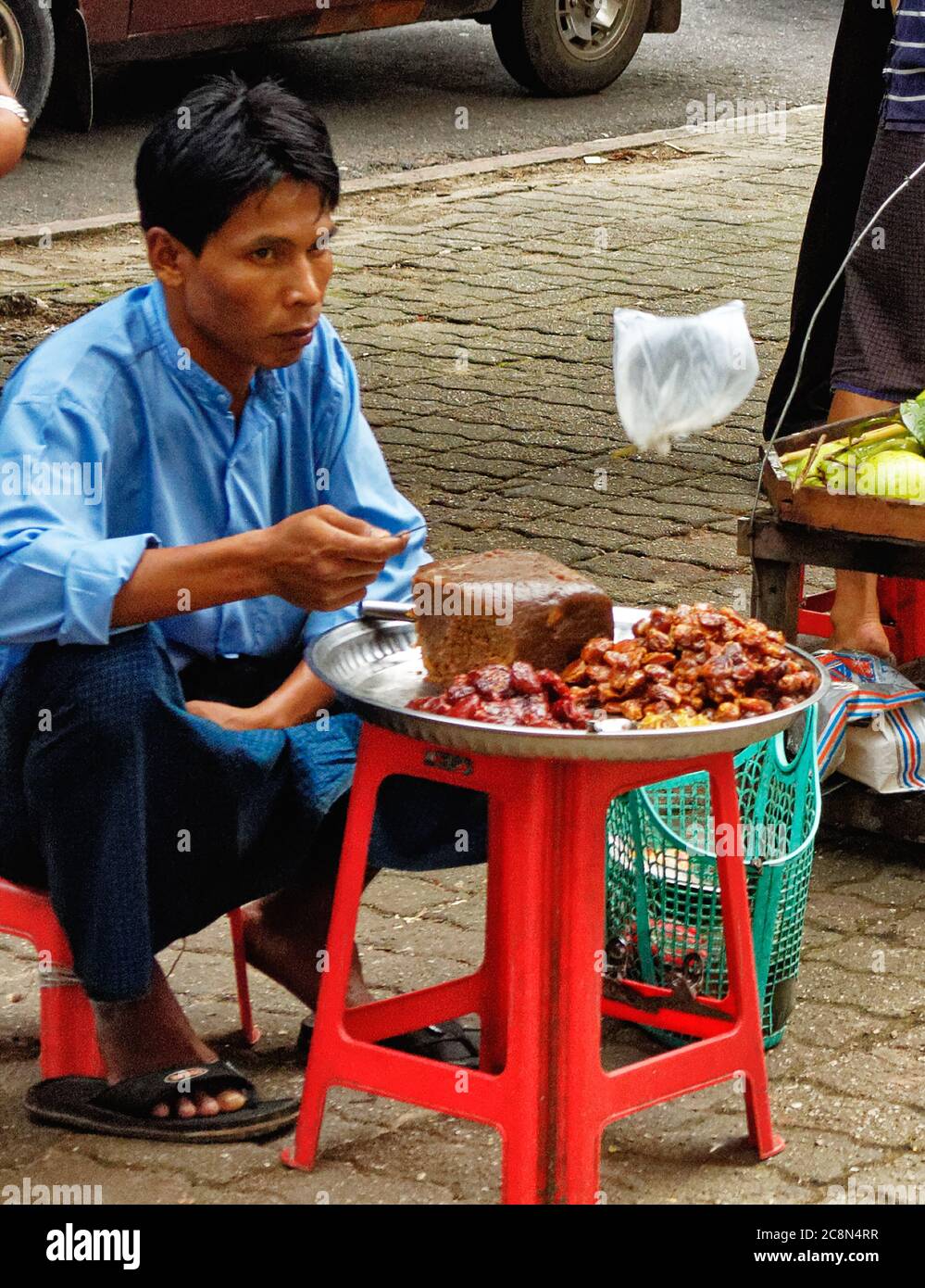 Hawker con un ventilatore per tenere gli inset lontano dal cibo caldo, Yangon, Myanmar Foto Stock