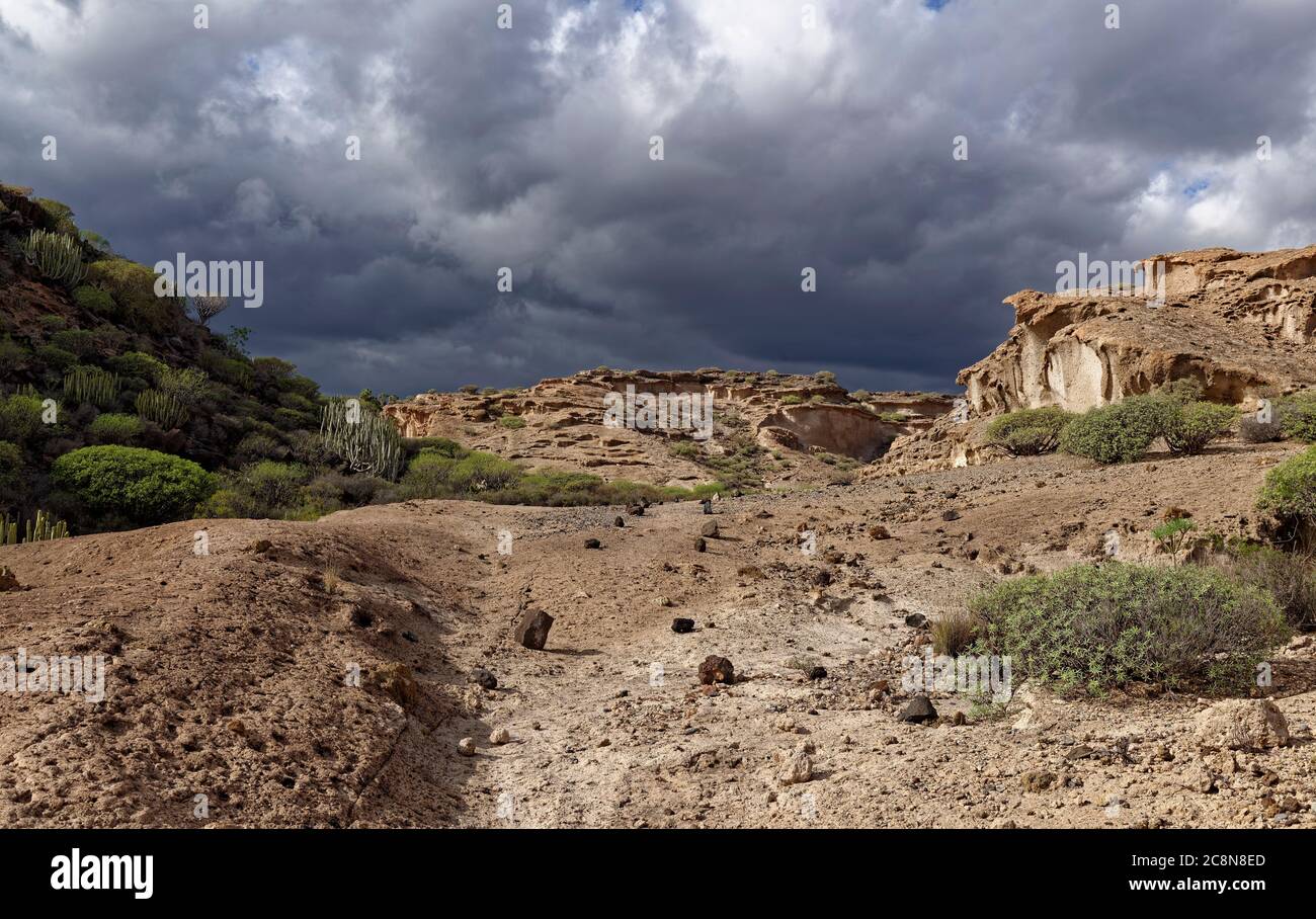 Un sentiero indistinto sul fondo della Valle di una piccola Valle formata da rocce vulcaniche erose d'acqua con piccole pietre che costellato il terreno. Foto Stock