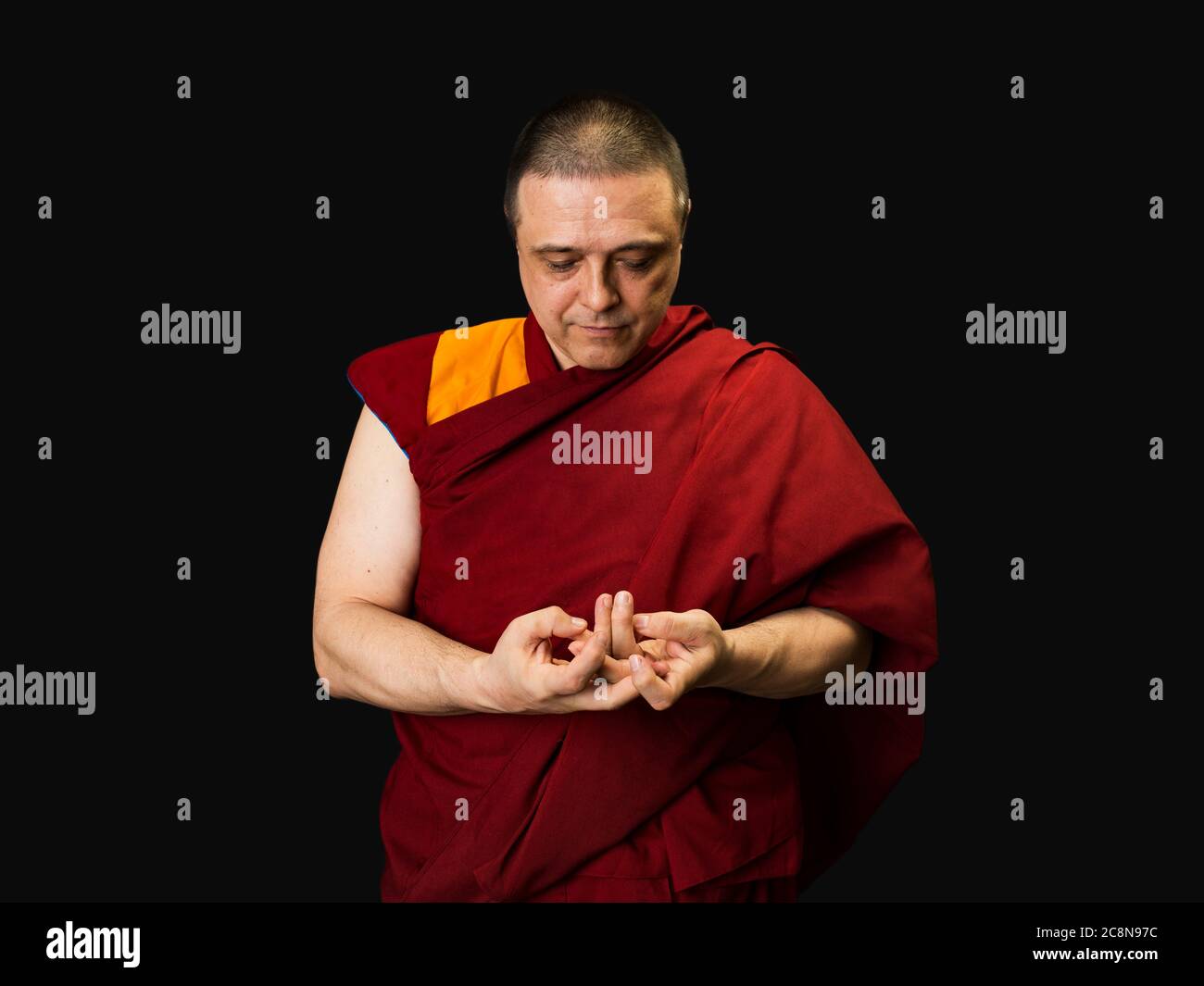 lama monaco ha piegato le sue palme e recita un mantra. Monakh è vestito con un vestito rosso lama Foto Stock