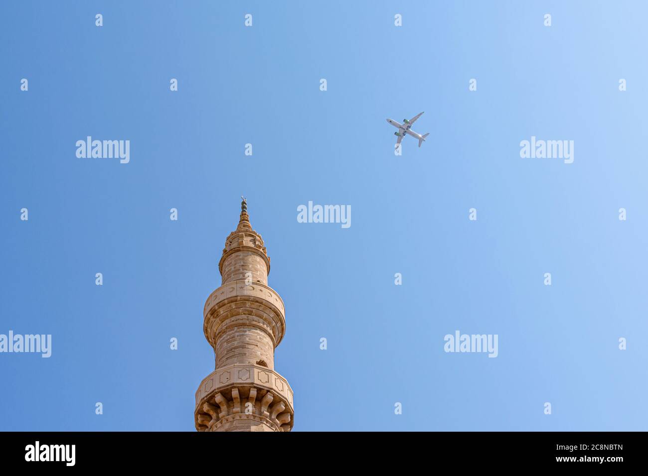 Un aereo vola sopra il minareto della Moschea di Suleiman nella vecchia città di Rodi, Grecia Foto Stock