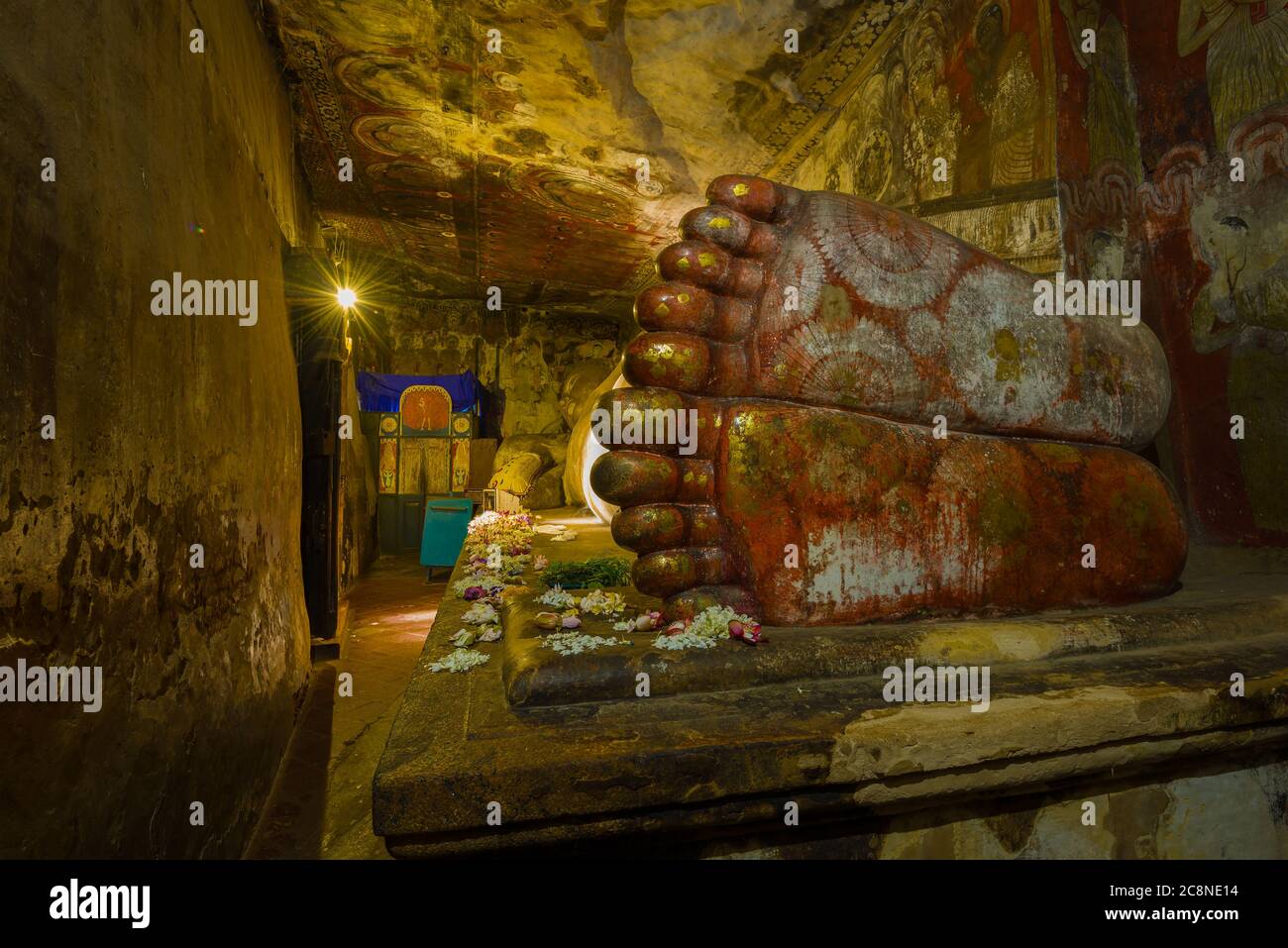 Vista dell'antica scultura gigante del Buddha reclinato dal lato dei piedi. Frammento dell'interno del tempio buddista Rangiri Dambulu Ra Foto Stock