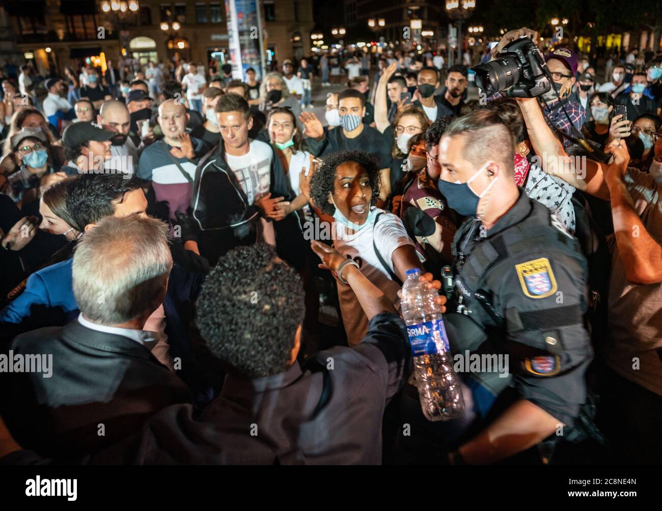 26 luglio 2020, Hessen, Francoforte sul meno: Il sindaco di Francoforte, Peter Feldmann (L.U.), è affollato sulla piazza di fronte all'Alte Oper per incontrare dimostranti che protestano contro la profilazione razziale, cioè che le persone sono controllate dalla polizia a causa del loro colore della pelle, colore dei capelli o altre caratteristiche esterne, ma senza alcuna ragione concreta. Questo fine settimana, per la prima volta, a partire da mezzanotte è stato vietato l'ingresso nell'Opernplatz, dove scoppiarono disordini una settimana fa. L'Opernplatz si era sviluppata in una zona di festa all'aperto negli ultimi mesi, anche in vista della chiusura dei club e. Foto Stock