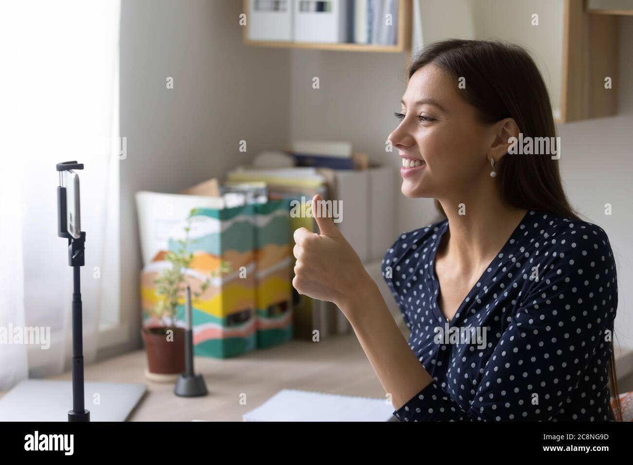 Sorridente ragazza sparare vlog raccomandando il servizio agli abbonati Foto Stock