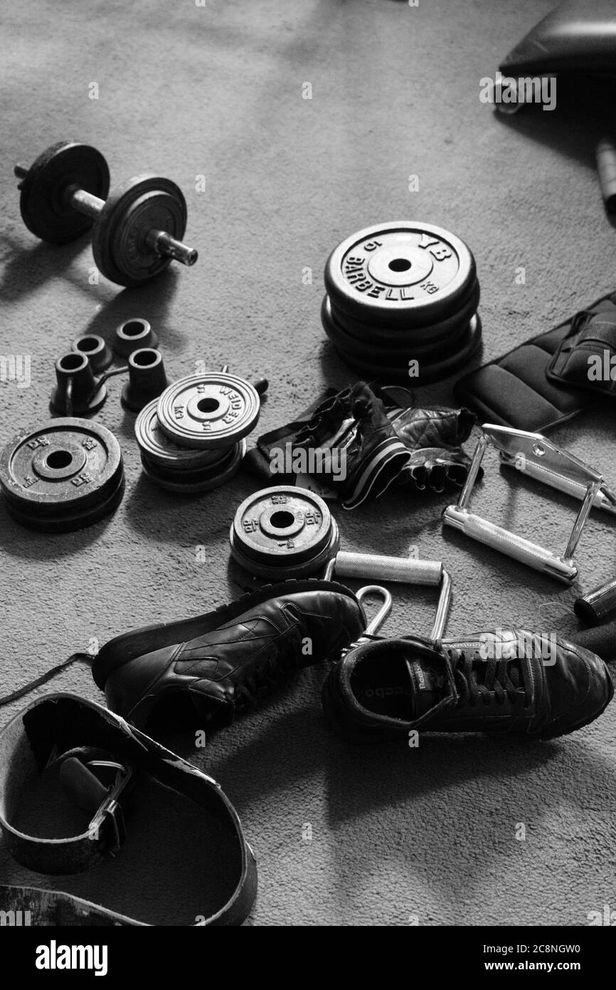 Una selezione di attrezzature per la costruzione del corpo, compresi manubri, addestratori, guanti e manubri, Harrogate, North Yorkshire, Inghilterra, Regno Unito. Foto Stock