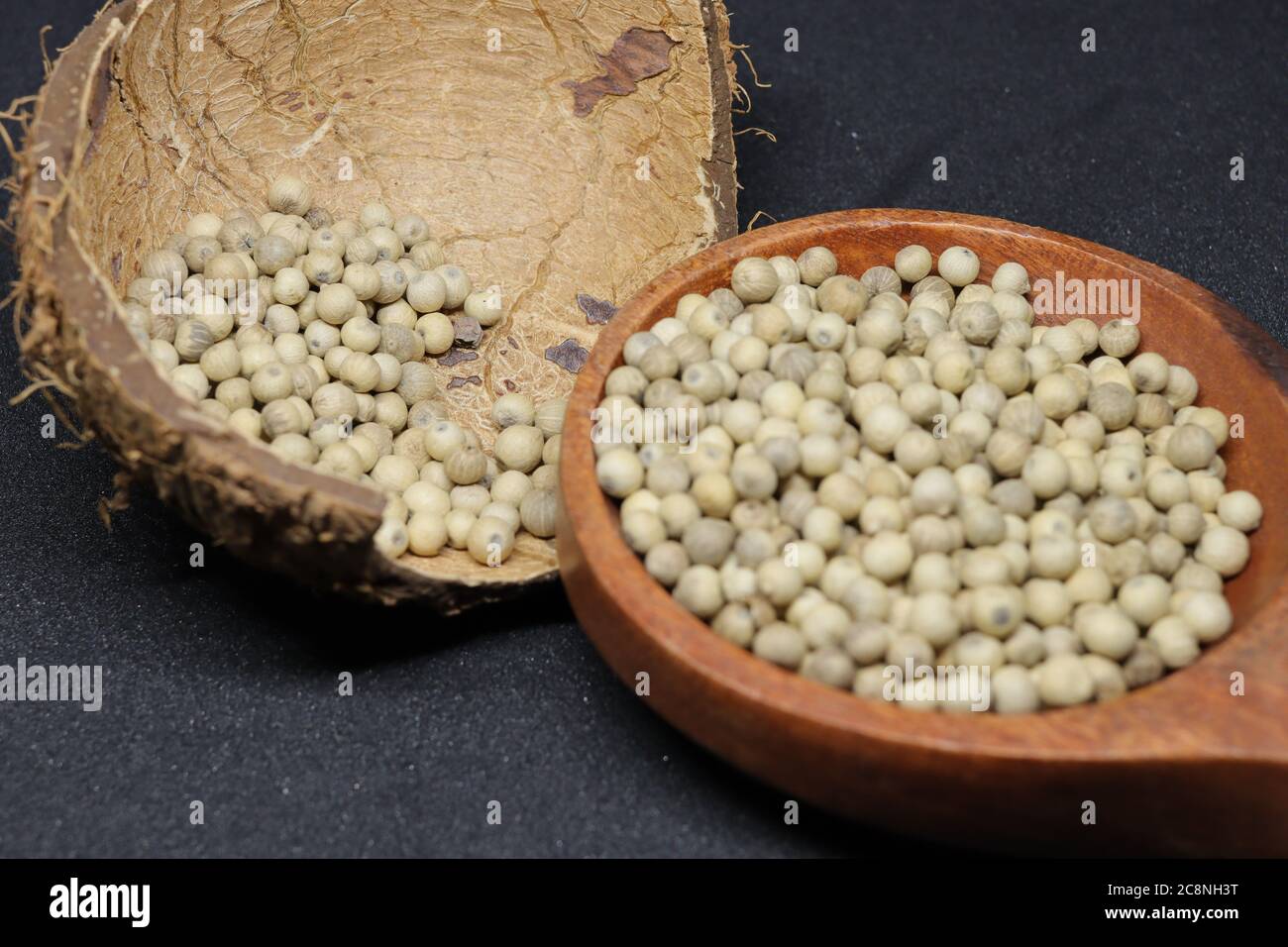 Grani bianchi di pepe isolati su sfondo nero Foto Stock