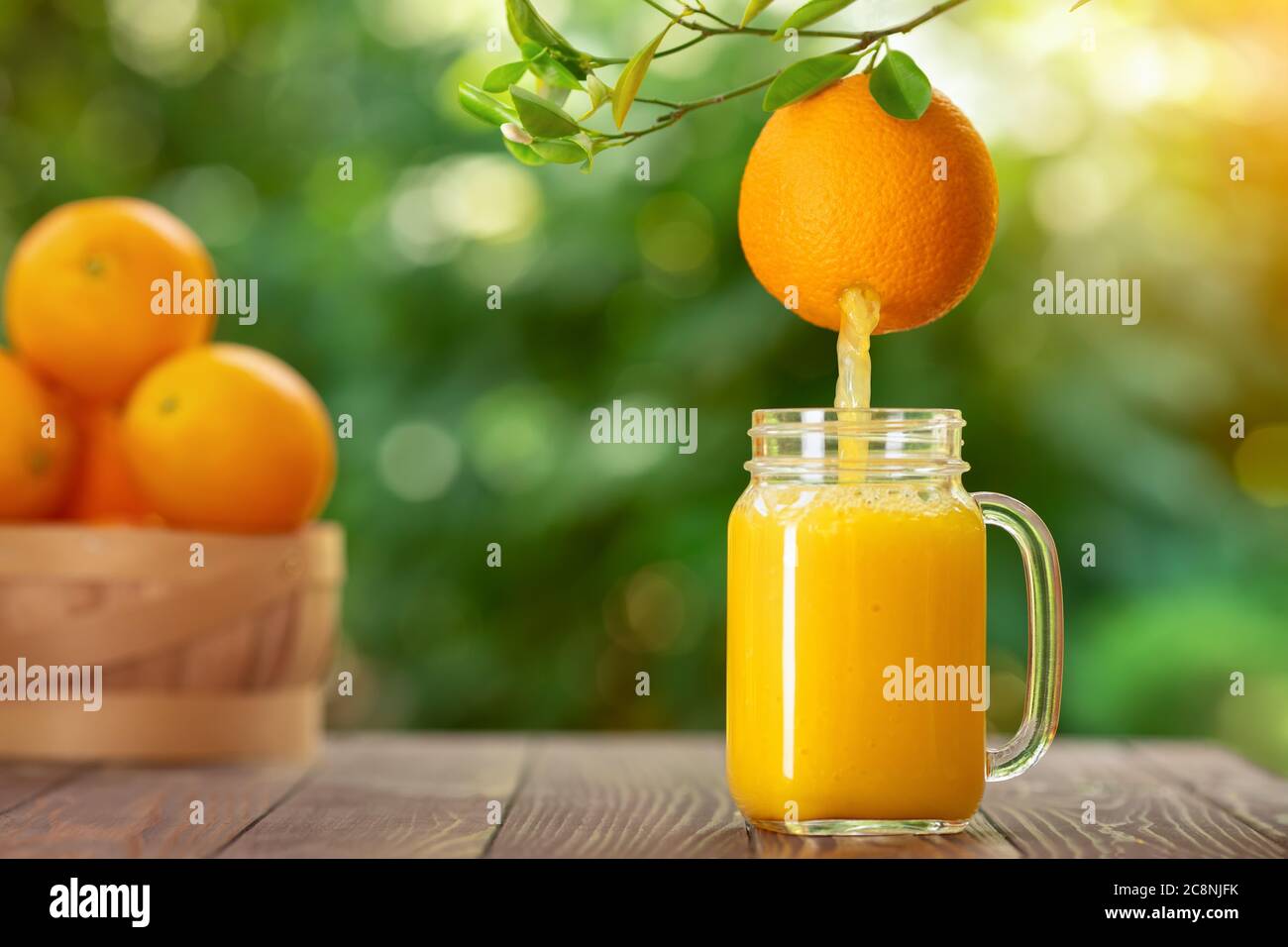 succo d'arancia versato nel vasetto di muratore Foto Stock