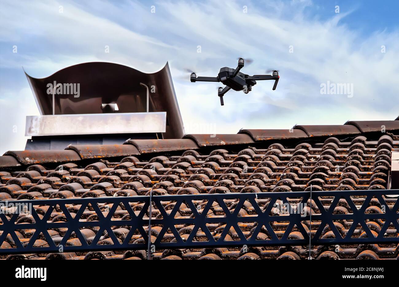 Drone in aria ispezionando il tetto sopra la casa. Primo piano del drone e  del tetto Foto stock - Alamy