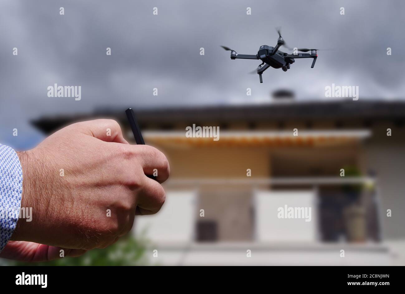 Drone in aria ispezionando il tetto sopra la casa. Primo piano del drone e del tetto. Foto Stock