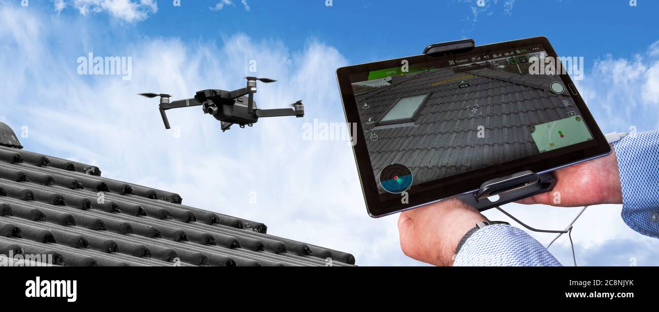 Drone in aria ispezionando il tetto sopra la casa. Primo piano del drone e del tetto. Foto Stock