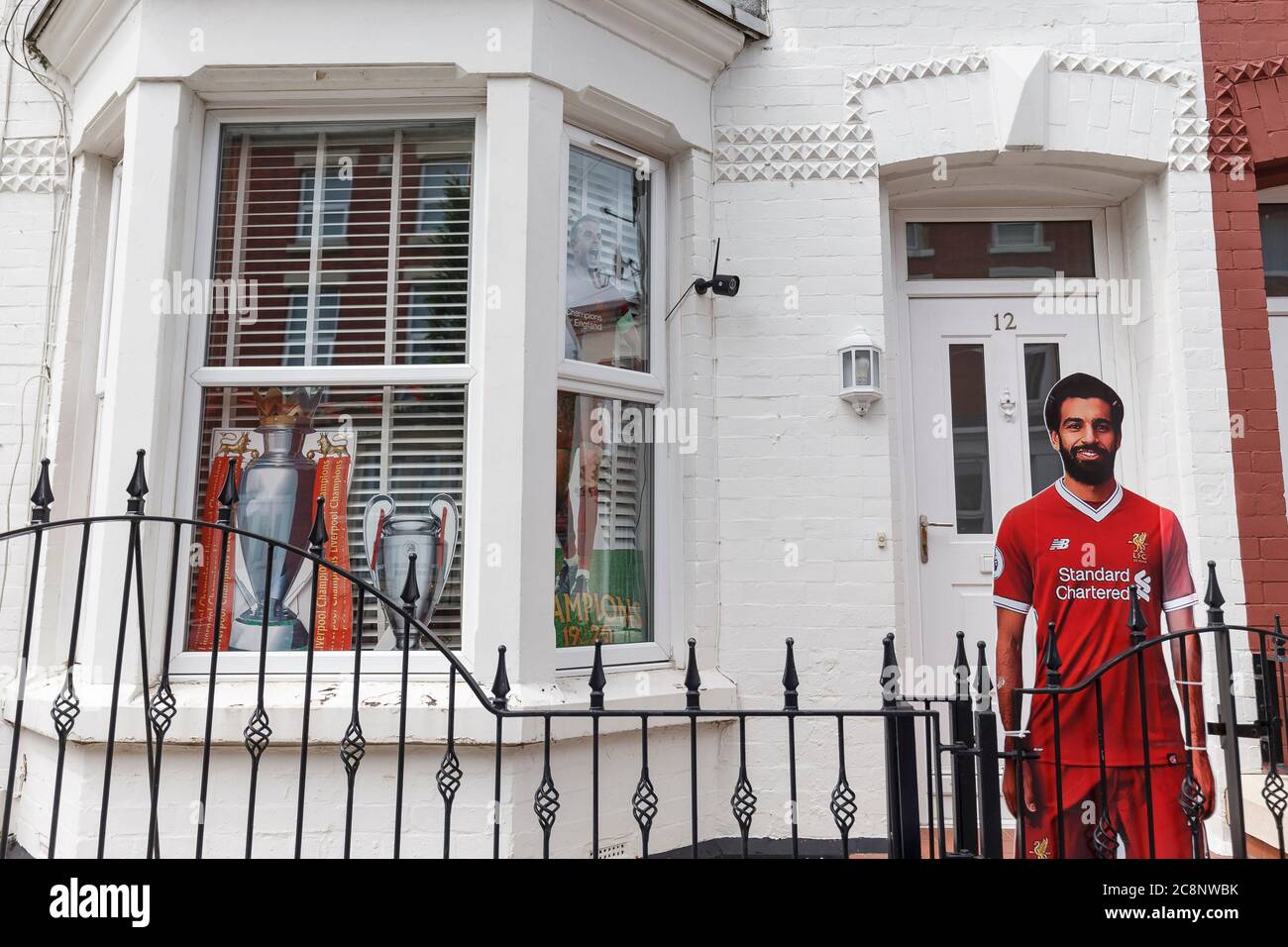 Liverpool, Regno Unito. 26 luglio 2020. Una casa è decorata con una sfinestratura di cartone di Mo Salah vicino ad un nuovo murale raffigurante il capitano di Liverpool Jordan Henderson che solleva il trofeo della Premier League vicino allo stadio di Anfield il 26 luglio 2020 a Liverpool, Regno Unito. (Foto di Daniel Chesterton/phcimages.com) Credit: PHC Images/Alamy Live News Foto Stock